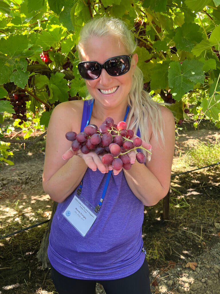 Mandy showing off the grapes at Jasmine Vinyards